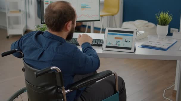 Hombre gerente paralizado utilizando la computadora y la tableta al mismo tiempo — Vídeos de Stock