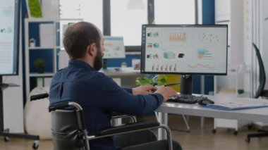 Etkisiz hale getirilmiş yönetici grafikleri analiz ediyor ve bilgisayarda yazıyor