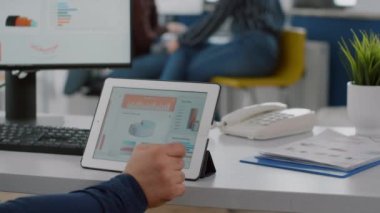 Tekerlekli sandalyede oturan felçli iş adamı tablette ve bilgisayarda çalışıyor.