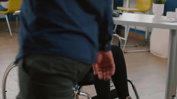 Paralized cacat duduk terimobilisasi di kursi roda memegang papan klip — Stok Video