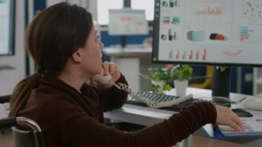 Felçli müşteri destek uzmanı müşteriyle telefonda konuşuyor.