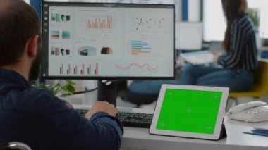 İzole edilmiş görüntülü tablete bakarak istatistikleri analiz eden felçli bir yönetici
