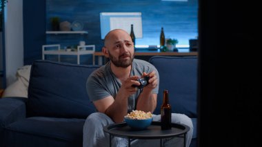 Kızgın ve hayal kırıklığına uğramış bir adam oyun kumandasını kaybediyor.