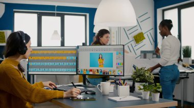 Kulaklık takan rötuşlayıcı stil kalem kullanarak resme rötuş yapıyor