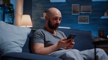 Çaresiz bir adam dijital bankacılık ödenmemiş faturalarını okuyor.