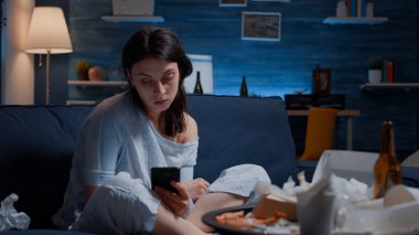 Cep telefonundan kötü haberler okuyan üzgün bir kadın.