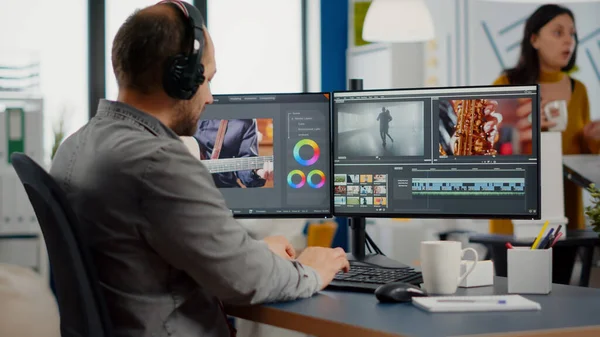 Videographer putting on headset editing video project — Stock Photo, Image