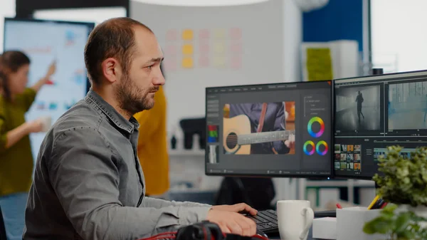 Videographer looking at camera smiling working in creative startup workplace — Stock Photo, Image