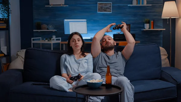 Неправильна пара, яка програє змагання онлайн-відеоігор за допомогою джойстика — стокове фото