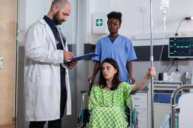 Hasta koğuşunda çalışan pano üzerinde sağlık uzmanlığı yazan doktor.