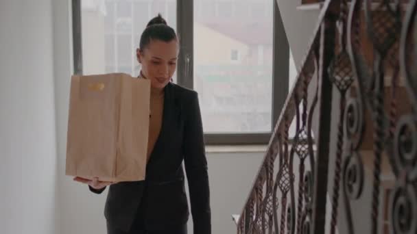 Femme d'affaires monter les escaliers dans le bureau de démarrage entreprise hoding emporter sac de repas alimentaire — Video