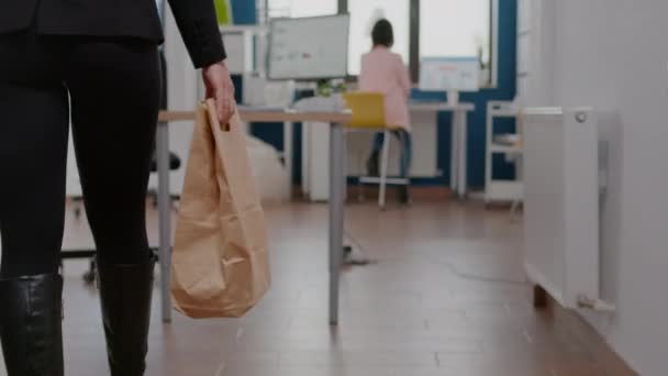 Geschäftsfrau hält Papiertüte mit Essensbestellung zum Mitnehmen auf Schreibtisch — Stockvideo