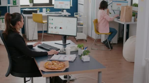 Bizneswoman na przerwie obiadowej przy stole jedząc pizzę fast food dostawy — Wideo stockowe