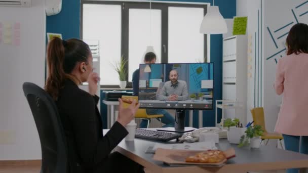 Mujer de negocios comiendo a domicilio pizza para llevar bebiendo café durante la conferencia de videocall en línea — Vídeos de Stock