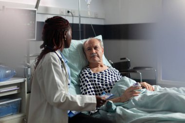 Hasta yatakta yatıp oksijen test tüpünden nefes alıyor.