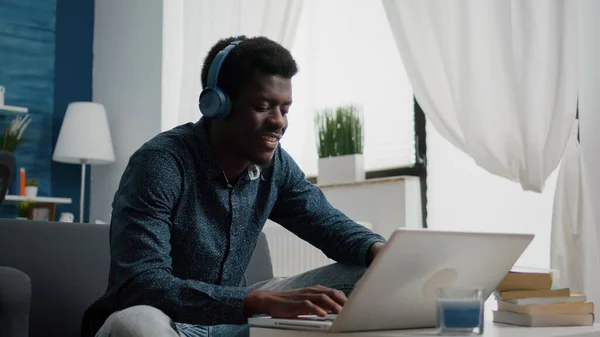 Negro africano americano homem vestindo fone de ouvido, digitando no laptop — Fotografia de Stock
