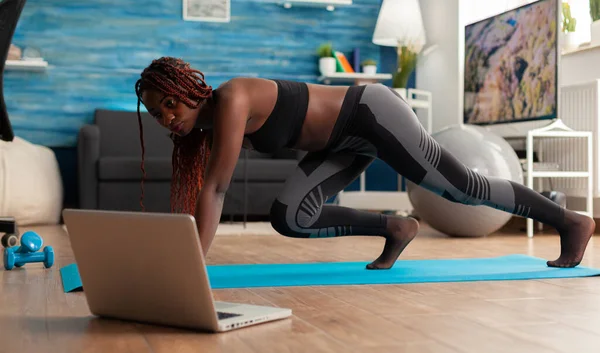 Adatto forte donna nera facendo tavola da corsa su tappetino fitness — Foto Stock