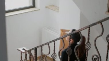Girişimci kadın şirket ofisinde merdivenleri tırmanıyor. Elinde yemek siparişi var.