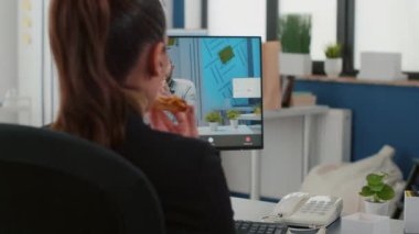 İnternetteki video konferans toplantısında servis pizzası yiyen yönetici.