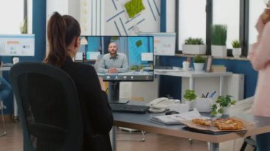İdari müdür, çevrimiçi video görüşmesi sırasında uzak üniversite arkadaşlarıyla pizza yerken tartışıyor.