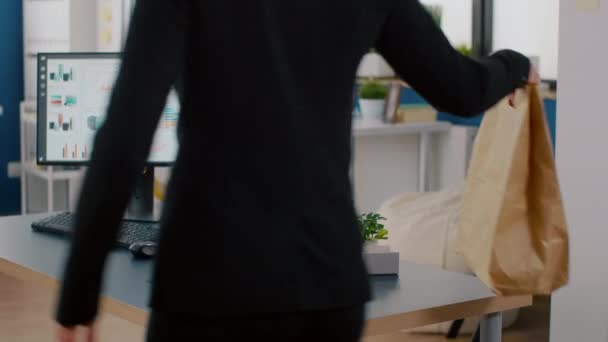 Alegre mujer de negocios poniendo comida para llevar paquete de pedido en la mesa de escritorio durante la pausa para el almuerzo — Vídeos de Stock