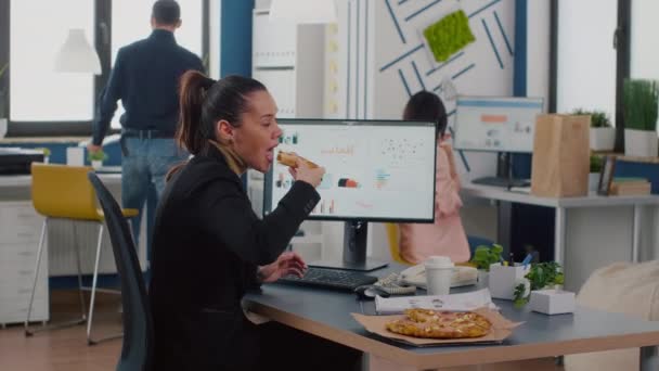 Ügyvezető menedzser eszik ízletes pizza gépelés közben pénzügyi statisztikák íróasztal a munkahelyen — Stock videók