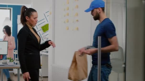 Delivery man bringing takeaway food meal order to businesswoman in startup company office — Stock Video