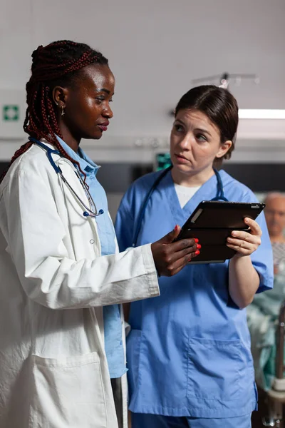 Medical nurse asking advice from african american doctor