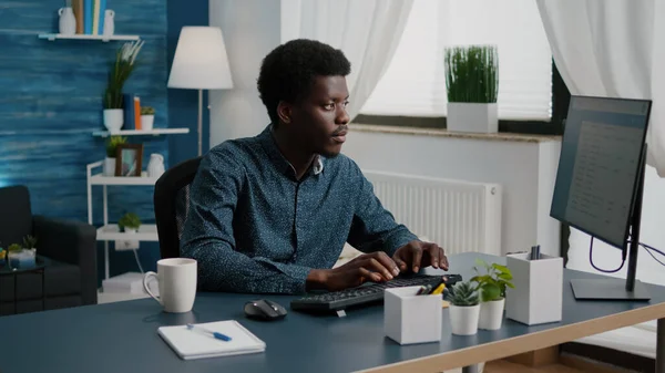 Black man computer user working from home in cozy flat