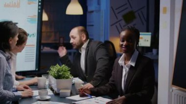 Odaklanmış gülümseyen Afrikalı kadının portresi şirket ofisindeki toplantı odasında oturuyor.