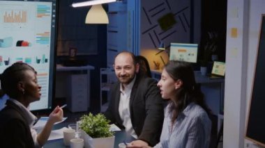 İş adamının portresi şirket toplantı odasında çok çalışan kameraya bakıyor.