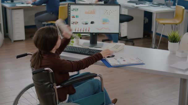 Druk bezette verlamde gehandicapte vrouw werknemer praten aan de telefoon met collega — Stockvideo