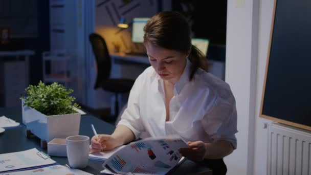 Przepracowany bizneswoman pisząc zysk finansowy na notebooku podczas pracy w firmie spotkania — Wideo stockowe