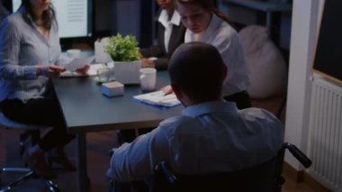 Tekerlekli sandalyedeki işkolik engelli liderin seçici odak noktası yönetim istatistiklerini tartışıyor