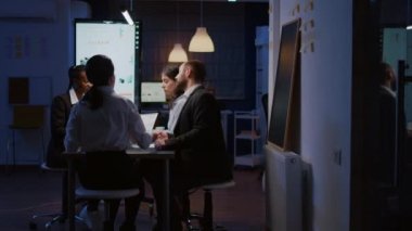 Gece geç saatlere kadar çalışan çok ırklı iş adamlarının seçici odak noktası