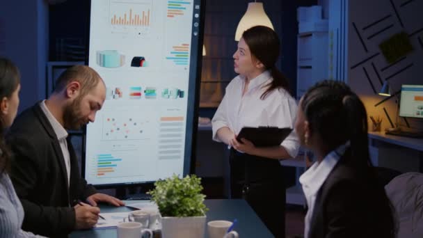 Workaholic pengusaha wanita menyajikan solusi perusahaan menggunakan monitor presentasi — Stok Video