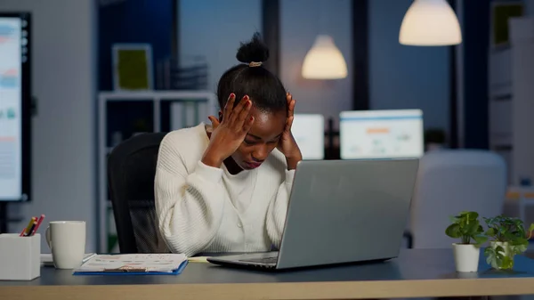 Stresszes afrikai üzletasszony szenved fejfájás a munkahelyen — Stock Fotó
