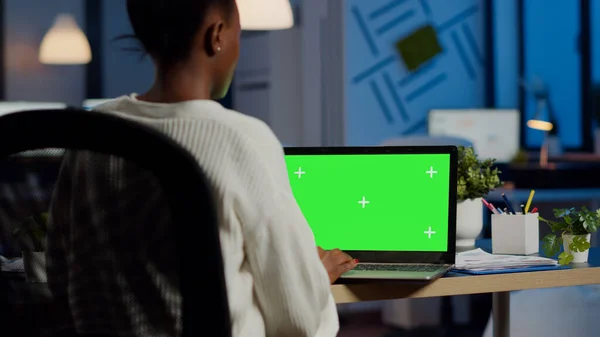 Mujer de negocios africana leyendo en el ordenador portátil con pantalla verde — Foto de Stock