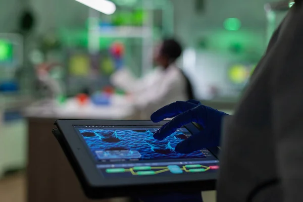 Scientist researcher doctor analyzing genetic mutation test using tablet