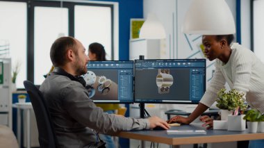 Endüstri mühendisi ve Afrikalı proje yöneticisi birlikte çalışıyorlar.