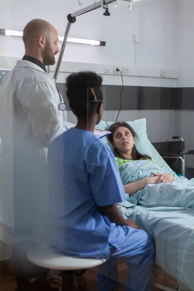 Medical team monitoring sick woman explaining sickness symptom — Stock Photo, Image