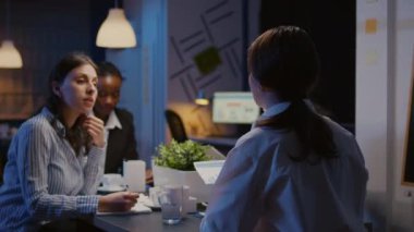 Çok ırklı yöneticiler iş belgelerini analiz eden mali grafikleri kontrol ediyor.