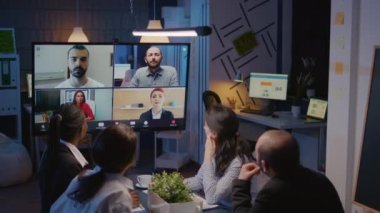Çevrimiçi video görüşmesi sırasında uzak iş arkadaşlarıyla tartışan çeşitli iş adamları grubu