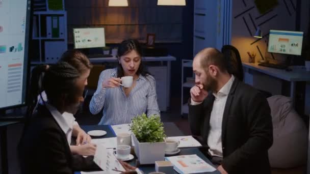 Бизнесвумен, держащая чашку кофе во время обсуждения с многоэтнической командной работой — стоковое видео