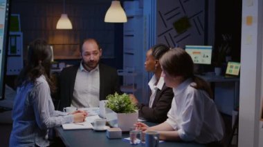 İşadamı çeşitli etnik çeşitlilikteki takım çalışması şirket istatistiklerini tartışıyor