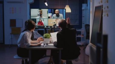 Çevrimiçi video konferansı sırasında şirket fikirlerini araştıran çok ırklı iş adamları
