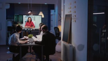Şirket ofisinde aşırı çalışan çok ırklı bir ekip çevrimiçi video konferansı yapıyor.