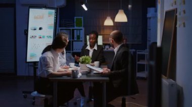 Afrikalı Amerikalı yönetici kadın finansal grafik sunumunu tartışıyor