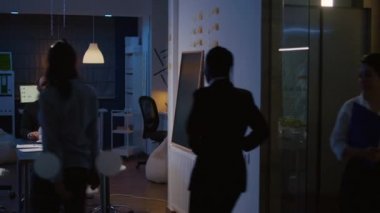 İş yerindeki toplantı odasına giren çok ırklı takım çalışması şirket stratejisini tartışıyor.