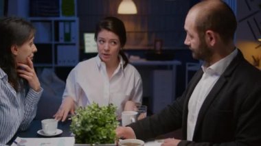 Muhtelif etnik çeşitlilikte takım çalışması ofis toplantı odasında mali grafikleri analiz ediyor